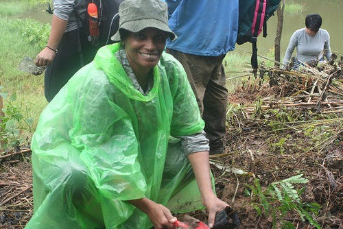 An image of Michelle Harris planting a tree in Thailand.