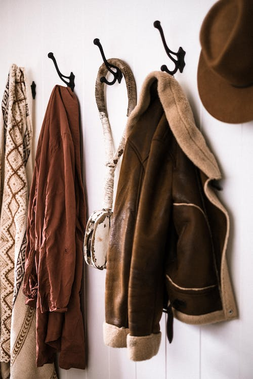 coats and clothes hanging on wall hooks