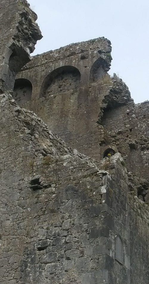 Gray, brown stone wall with crumbling edges and parts