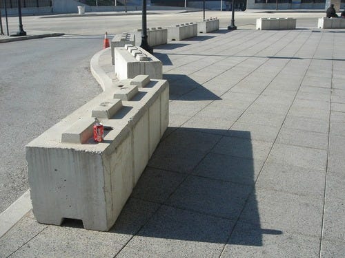 Concrete rectangular blocks with 4 protruding smaller rectangular blocks on top to limit seating area.
