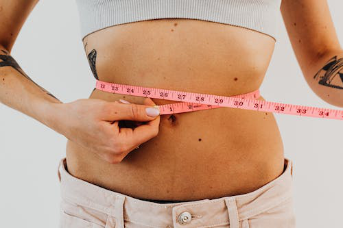 A woman measuring her waist