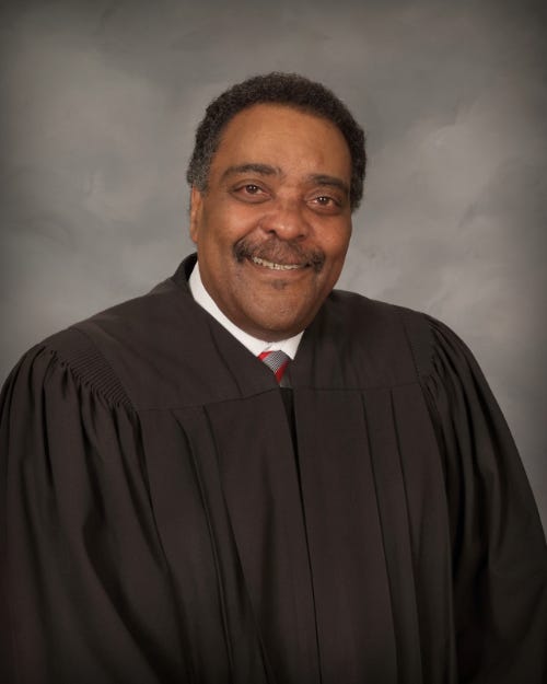An image shows Judge Hugh Scott.