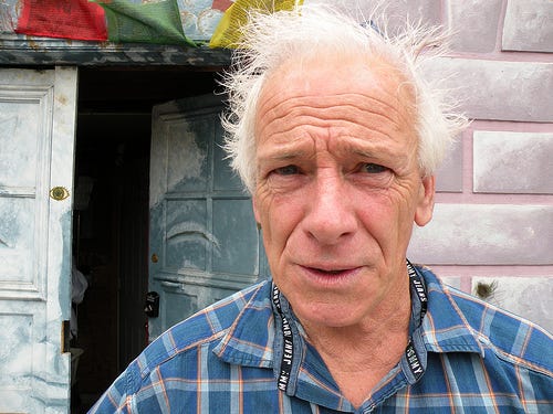 Dennis Peron, a white man in his sixties with fluffy white hair, wearing a blue plaid shirt