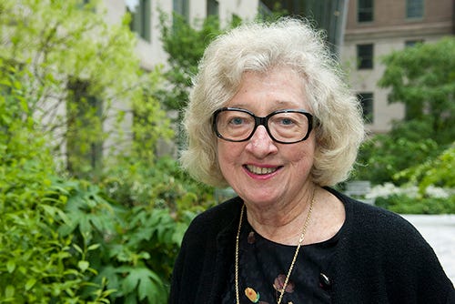 Portrait photo of Mary Jeanne Kreek with plants and buildings in the background