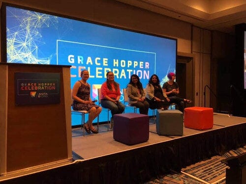 Nandita Gupta (center) sitting with four other panelists at the Grace Hopper Celebration Conference held at Orlando FL,2019.