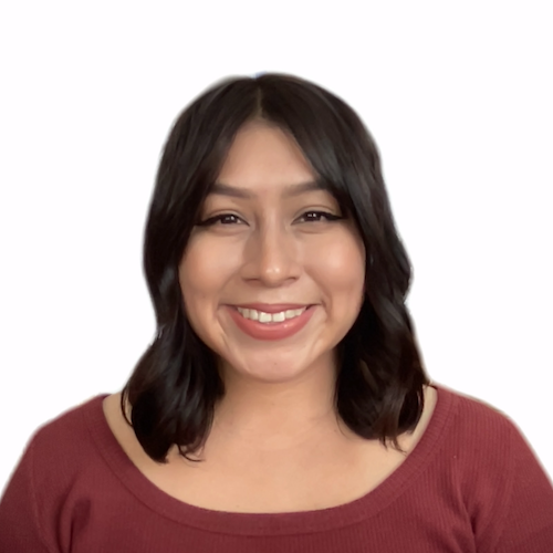 Photo of Yolis, a Hispanic woman, from the chest up. She is looking at the camera with an open-lipped smile. She is wearing a burgundy top. Her short brown curls are brushing both shoulders.