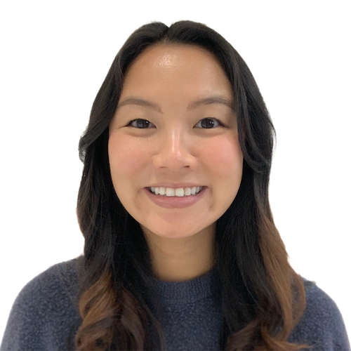 Photo of Cathy, a Vietnamese-American woman, from the shoulders up. Her dark brown hair is in curls, and the ends of her hair are light brown. She is wearing a blue top and smiling.