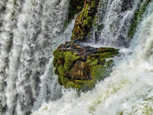 Iguazu Falls flowing over green outcrop