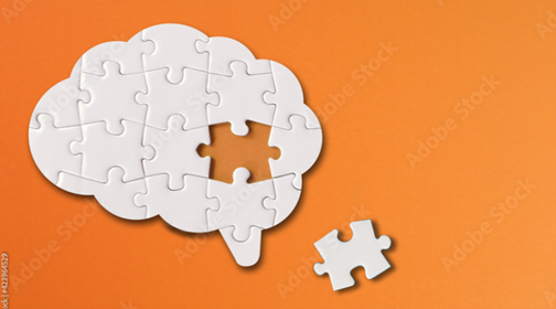 A brain made up of jigsaw pieces with a piece missing laid to one side