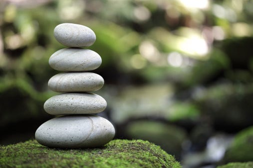 rocks stacked on top of each other on a moss-covered rock.