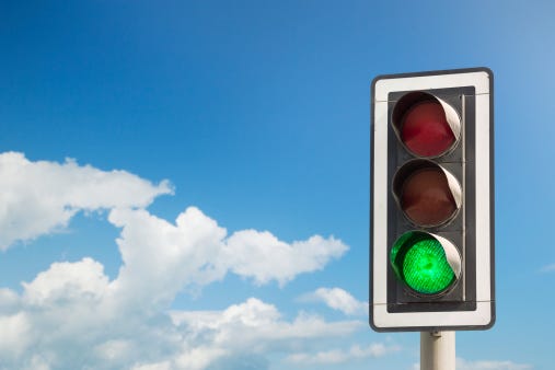 A picture of a stoplight with the green light illuminated.