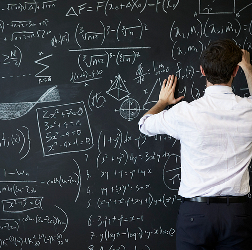 Person writing equations on blackboard