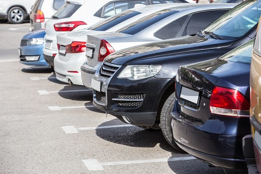 Cars parked in a parking lot on a sunny day.