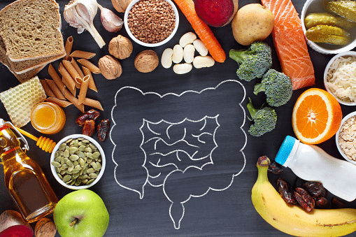 A chalk drawing of intestines, surrounded by actual, healthy foods.