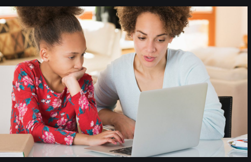 A mother guarding her ward looking at a screen while learning