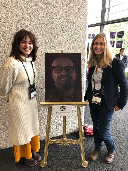 Artist Violet Jones and NFT Collector Charmaine Short beside a portrait of Alotta Money