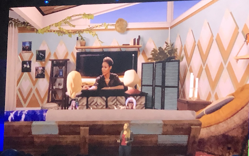 We see blond avatars sitting on a couch in an animated living room, and they appear to be watching Jada Pinkett Smiths show "Red Table Talk."