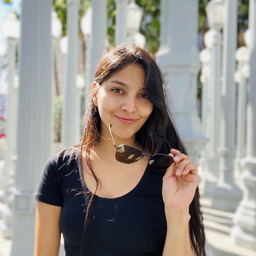 Elda smiling in front of Public Art “Urban Light” in LA