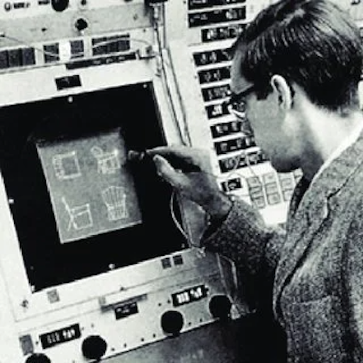 Ivan Sutherland using the Sketchpad light pen on the TX-2 computer console at MIT. A man points at an early visual computer interface with a wired light pen