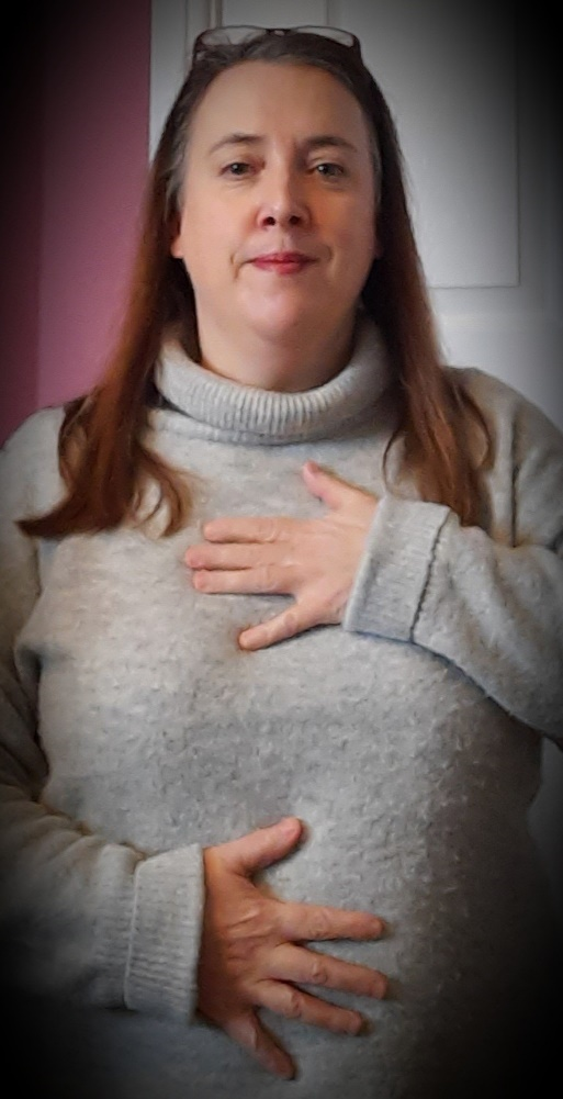 A woman practising belly breathing with one hand on her chest and the other on her stomach