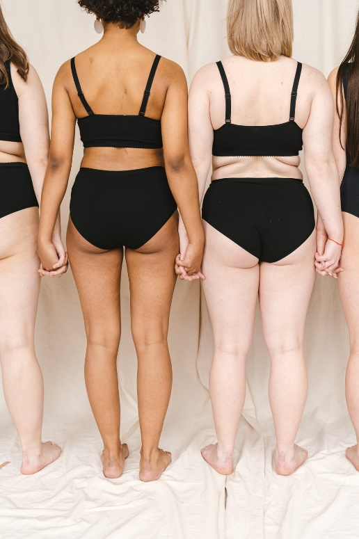 Women of different sizes standing and holding hands
