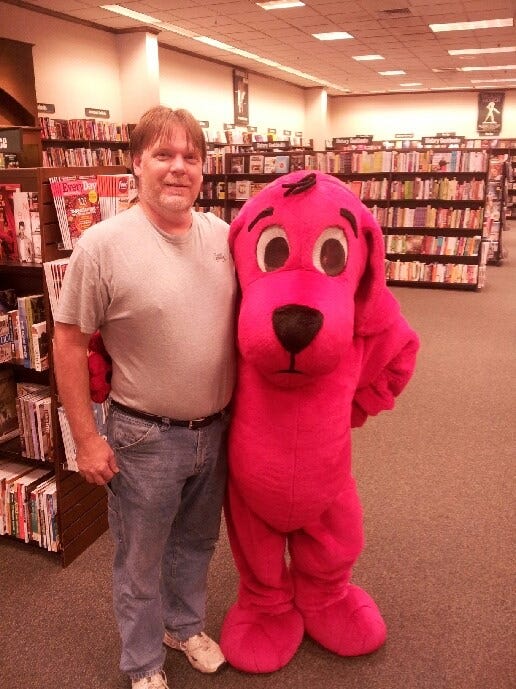 A man and the author in a Clifford the Big Red Dog costume at a bookstore.