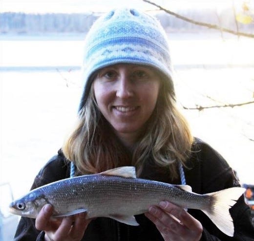 a woman holding a fish