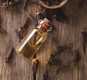 The essence of cloves in the bottle close-up on the table. vertical view from above