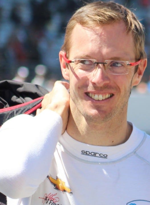 Sébastien wearing his racing fireproof underlayer walking with a bag slung casually over one shoulder.