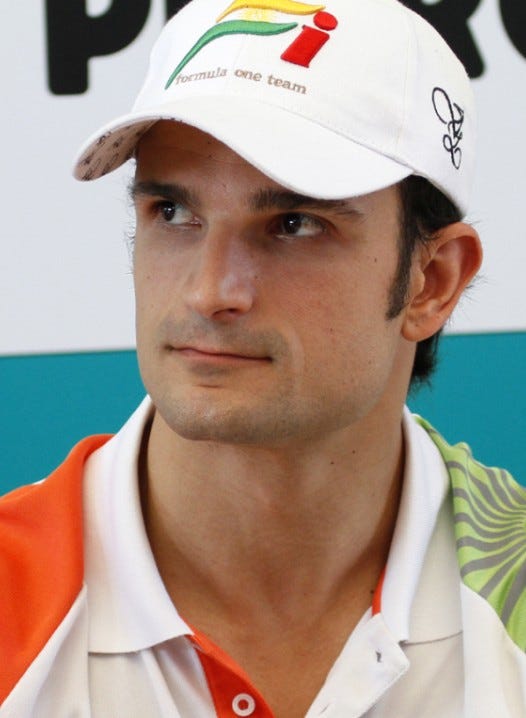 Luizzi wearing the Force India team shirt and cap against a blue and white background.