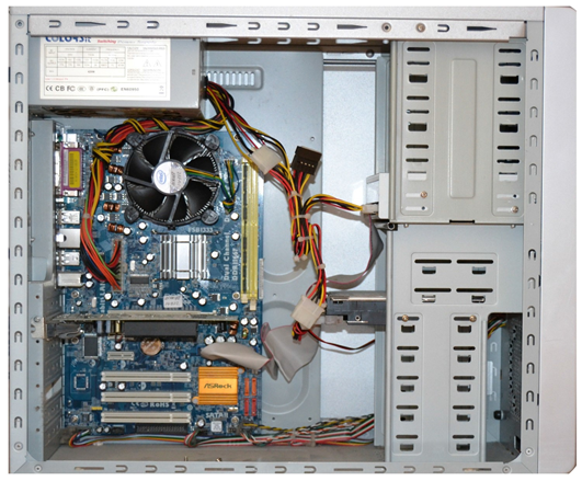 An old opened-up computer case showing the motherboard, flat cables, and circuits.