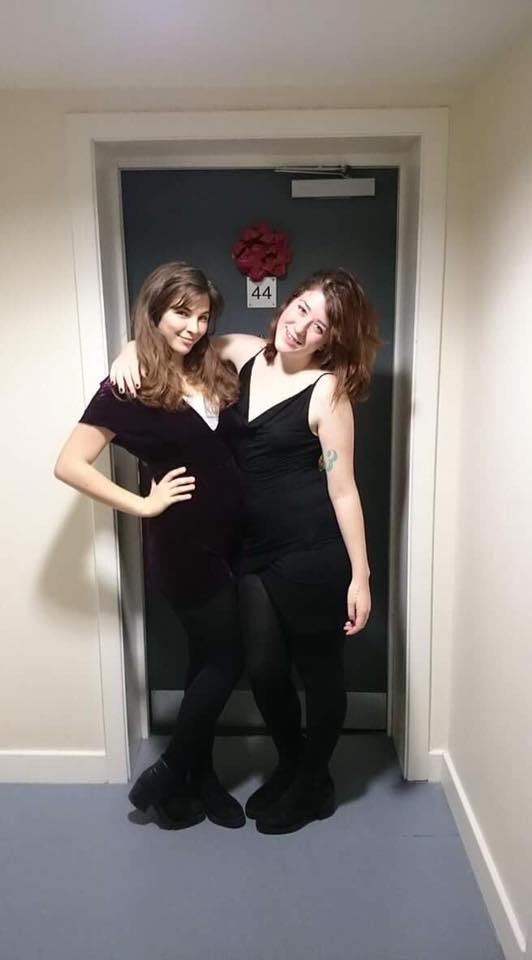 Two girls standing outside a door of their flat