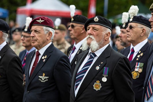 Armed Forces veterans stand in a row whilst wearing the ceromonial uniform.
