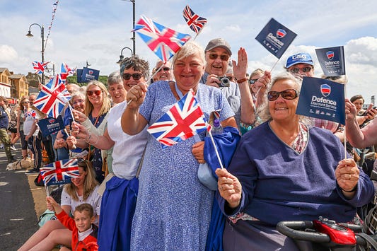 Members of the British public fly Union Jack flags as the attend the event.