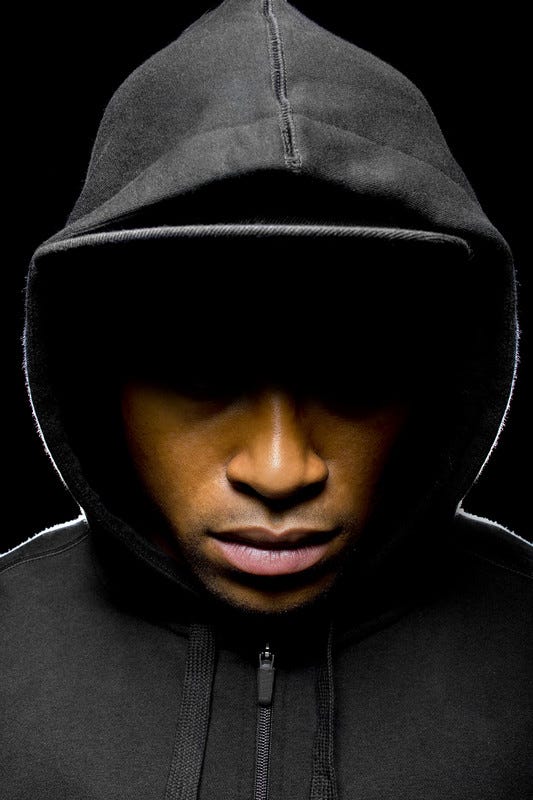 Young black man with hooded sweatshirt, eyes in shadow