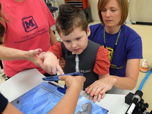 A 7-year-old patient uses SpellBound with his Occupational and Physical therapists. Photo: Lon Horwedel / Special to The Detroit News