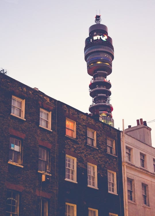 A photo of a block of flats at dusk with the BT tower in the background