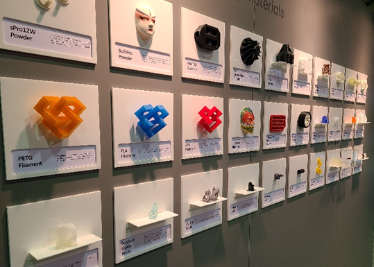 Wall of many small 3D printed samples (30 or so) from different 3D printing materials.