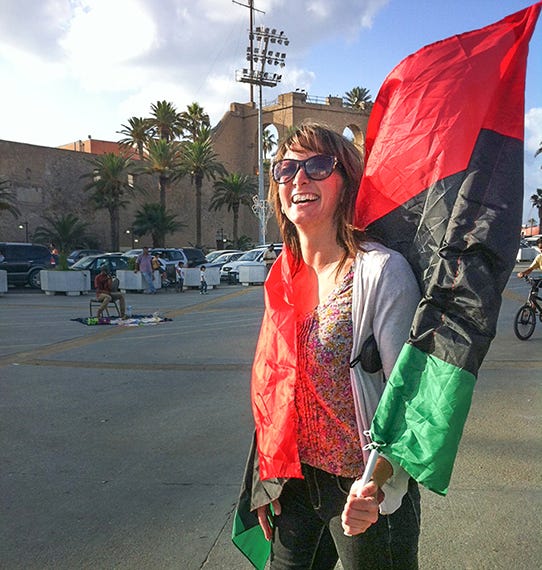 Erica Kaster with a Libyan flag in the main square of Benghazi, Libya, 2011. Photo courtesy of Erica Kaster