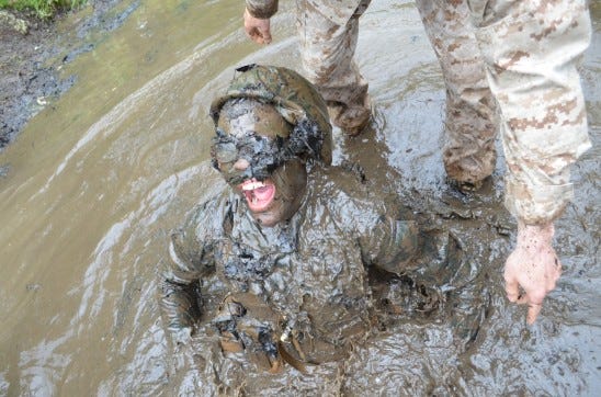 A muddy candidate gasps for air after getting stuck in the underwater portion of the Quigley