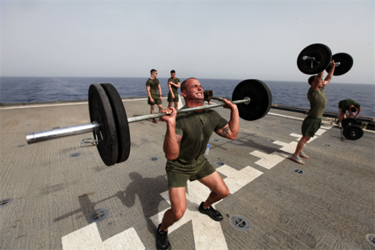 Staff Sgt. Jeffrey Perry, a Middlesex, N.J., native and the motor transportation chief with Motor Transportation Platoon, Combat Logistics Battalion 24, 24th Marine Expeditionary Unit, lifts weights during a CrossFit workout on the flight deck of the USS Gunston Hall, June 14, 2012. The 24th MEU, along with the Iwo Jima Amphibious Ready Group, is currently deployed to the U.S Central Command area of operations as a theater reserve and crisis response force. The group is providing support for maritime security operations and theater security cooperation efforts in the U.S. Navy's 5th Fleet area of responsibility. (Photo by Sgt. Richard Blumenstein)