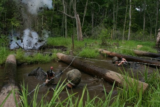 A simulated artillery round explodes near candidates navigating the infamous Quigley