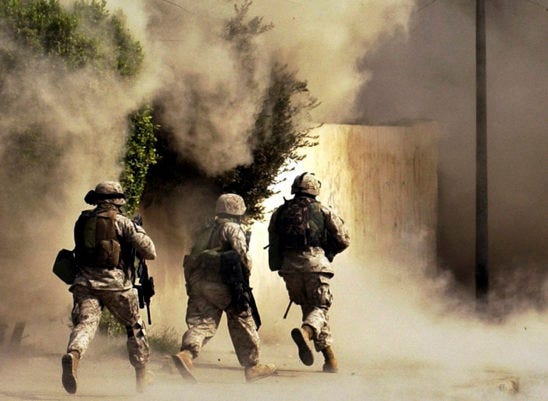 Oct. 26, 2004 U.S. Marines from the 2nd Battalion, 5th Marine Regiment, run to a building after detonating explosives to open a gate during a mission in Ramadi in Anbar province, Iraq.