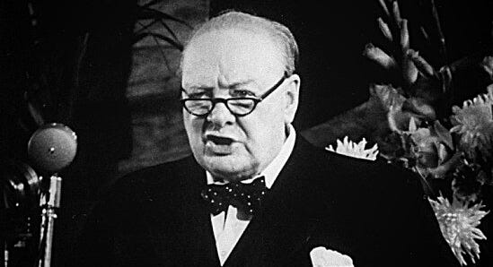 A black-and-white photo of Winston Churchill giving a speech
