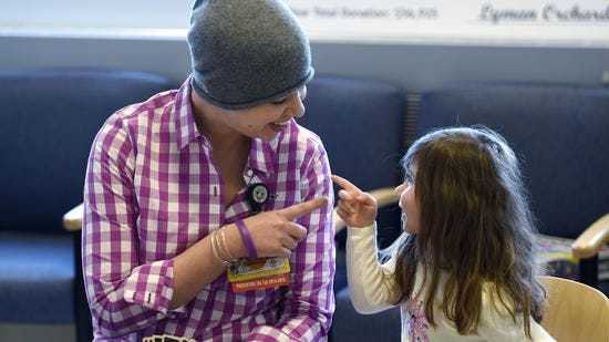 Pia Drown, 4, of Southington, plays a spirited game of cards with child life therapist and fellow cancer patient Jennifer Wheaton. (MICHAEL McANDREWS / Hartford Courant)