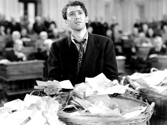 Black and white clip from the movie Mr. Smith Goes to Washington, showing the senator holding letters in each hand in the Senate; He looks haggard and defeated.