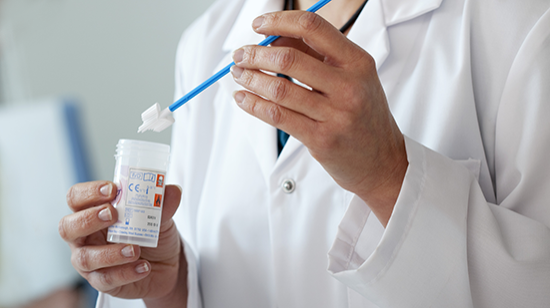 A picture of a clinician holding a cervical screening brush