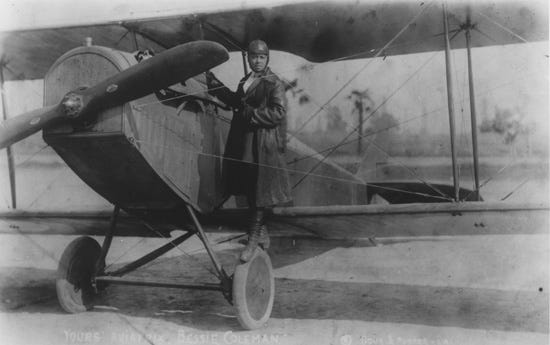 Bessie Coleman posing with her plane.