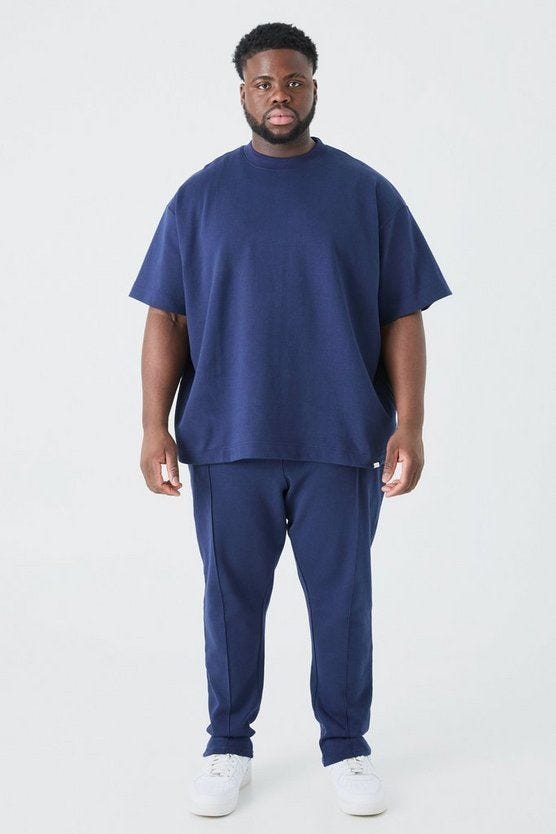 A man bith big belly wearing and styling a blue t-shirt and Joggers.