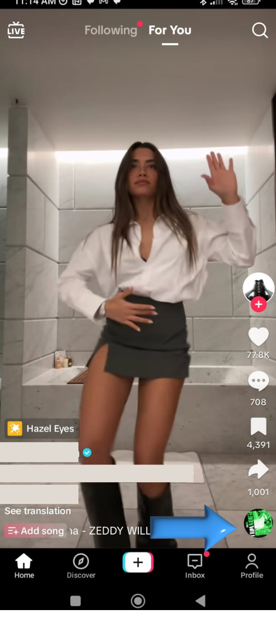 A screenshot of a TikTok video, with an arrow pointing to a spinning record at the bottom right of the screen